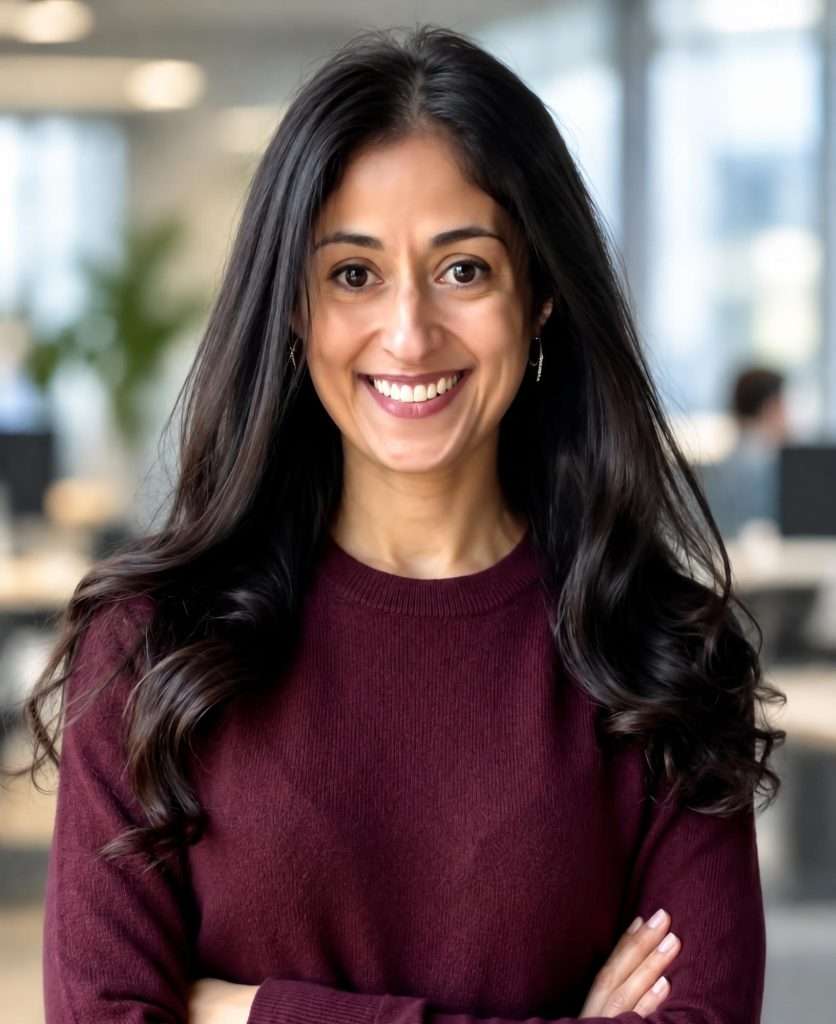 Smiling woman in office setting, representing Sara Ali's personalized psychiatric care.