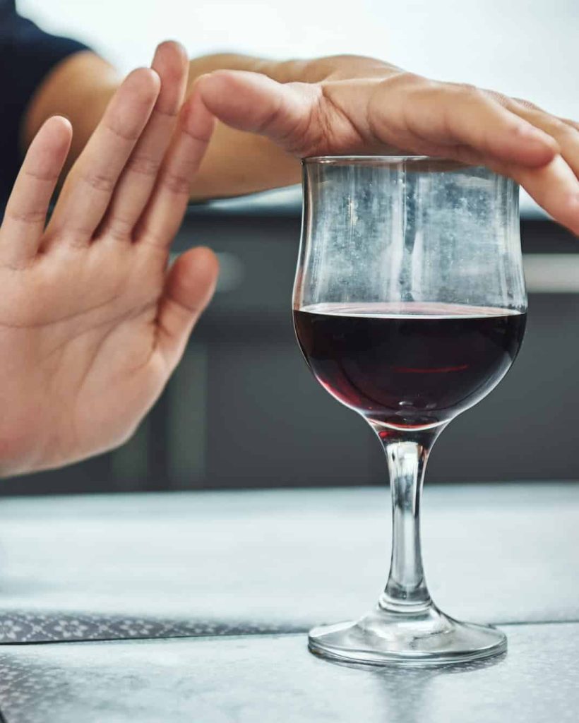 A small step toward recovery is giant progress. Addicted woman refuses to drink a glass of red wine